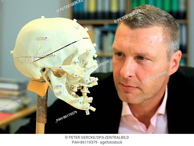 The spokesperson of the State Criminal Office, Andreas von Koß, watches the skull of an unknown dead person at the State criminal office in Magdeburg, Germany