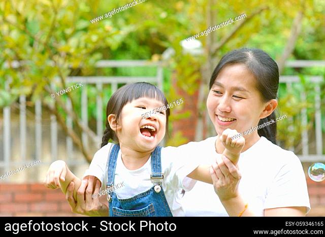 Enjoying time together.Lifestyle portrait asian mother and daughter in happines at the outside of garden park