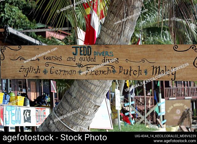 Wooden dive centre sign advertising multilingual instruction Coral Bay Perhentian Kecil Malaysia