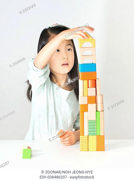 little Asian girl playing colorful wood blocks