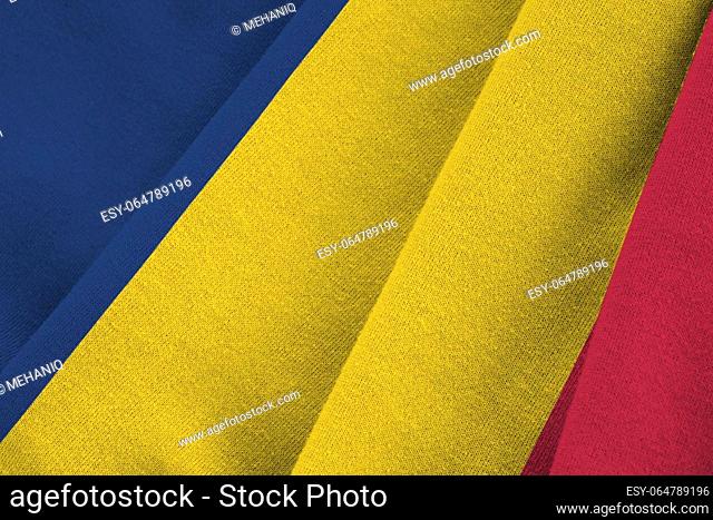 Chad flag with big folds waving close up under the studio light indoors. The official symbols and colors in fabric banner