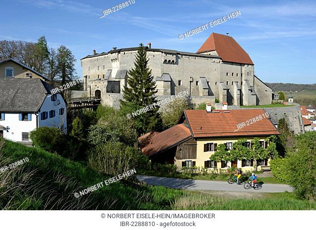 Cyclists on electric bicycles in front of Burg Tittmoning Castle, Chiemgau region, Upper Bavaria, Bavaria, Germany, Europe
