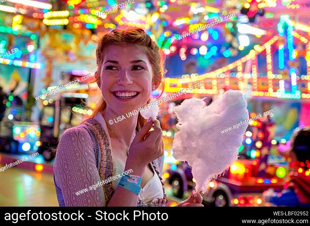 Portrait of happy redheaded teenage girl with candy floss at Oktoberfest