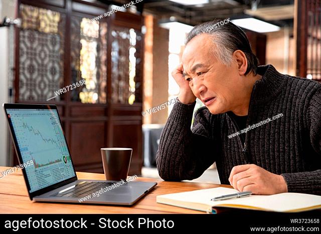 Old people use the computer to check the stock market