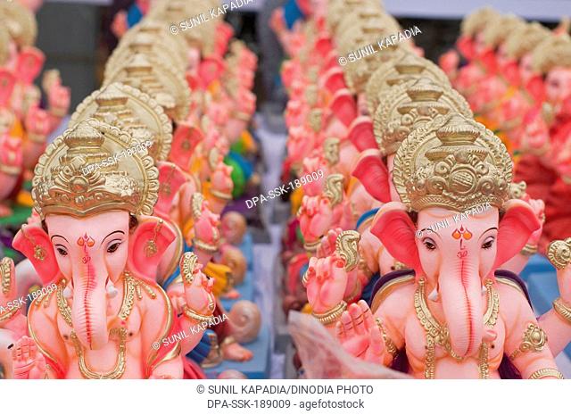 Several small idols of lord Ganesha line up for sale Pune Maharashtra India Asia