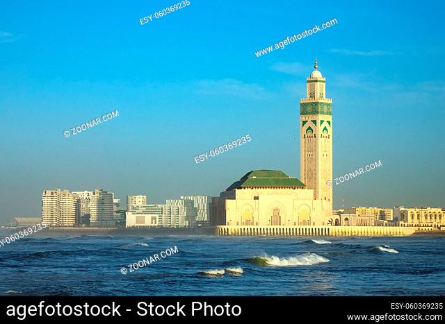 Hassan II mosque in Casablanca and Atlantic ocean waves at sunset, Morocco