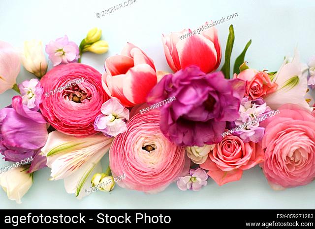 Top view of organic fresh flowers arranged in beautiful compositions on blue background