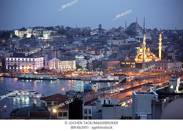 View across the Eminoenue district with the Galata Bridge spanning the Golden Horn and the New Mosque in front of Nuru Osmaniye Mosque, Istanbul, Turkey