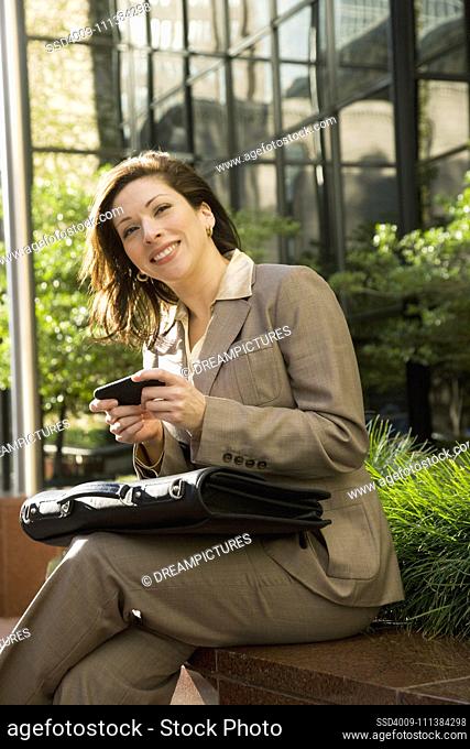 Hispanic businesswoman holding cell phone