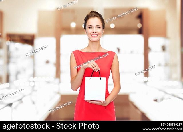 smiling woman with shopping bag at jewelry store