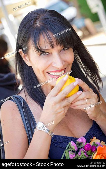Pretty Italian Woman Smelling Fresh Oranges at the Street Market