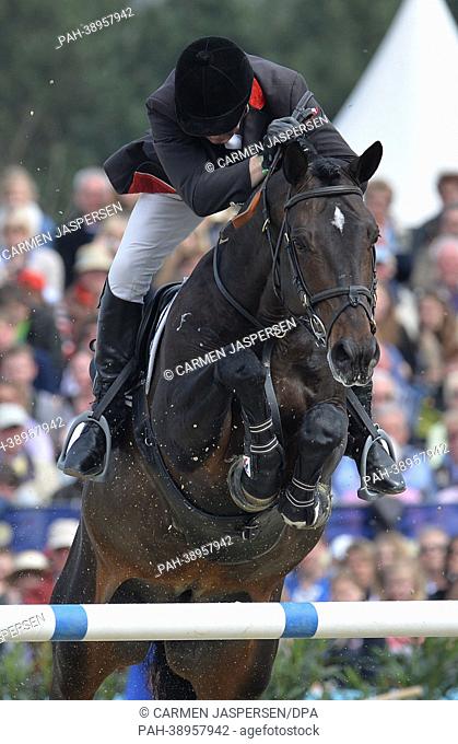 British horse rider John Whitaker performs his skills with his horse 'Argento 11' during the Grand Prix Deutschen Kreditbank AG of the equestrian event Horses &...