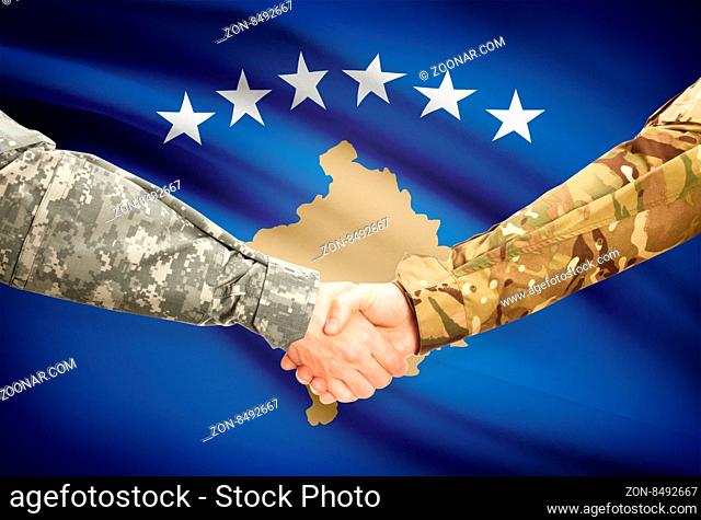 Soldiers shaking hands with flag on background - Kosovo
