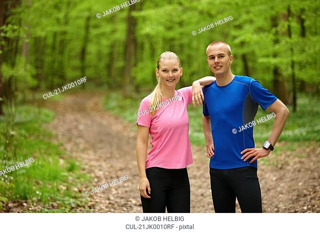 Couple running in forest, standing still