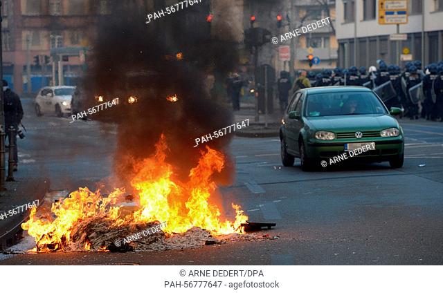 A car drives past burning barricades prior to the opening of the new European Central Bank (ECB) headquarter in Frankfurt, Germany, 18 March 2015