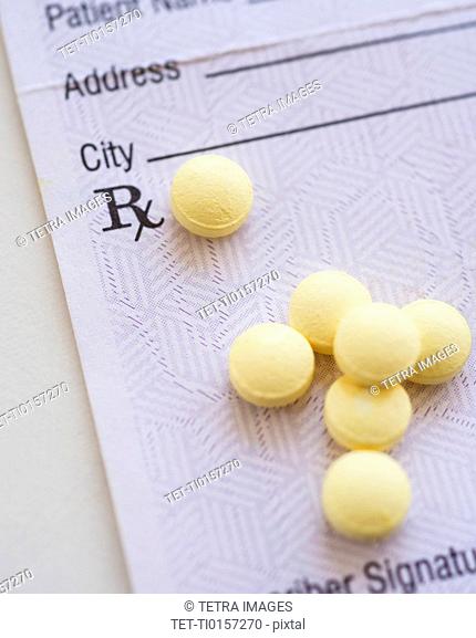 Yellow pills with prescription form, studio shot