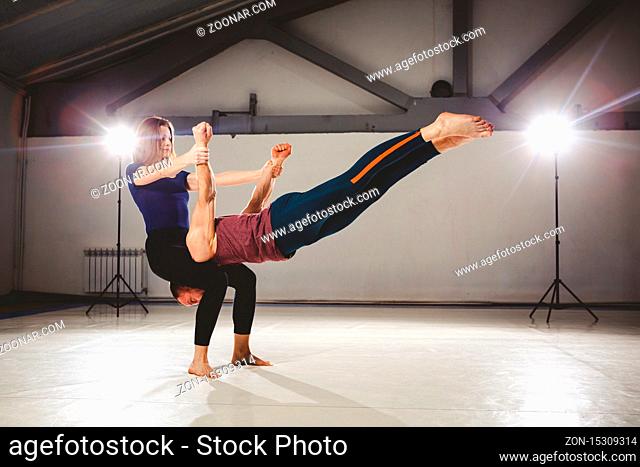 The theme of Acroyoga and Yoga Poses. Acroyogis practicing. with the studio Backlight. The woman Base keeps the man Flyer in the horizontal position Static...