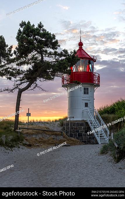 26 June 2021, Mecklenburg-Western Pomerania, Hiddensee: The sun sets behind the Gellen lighthouse. The lighthouse stands in the core zone of the Vorpommersche...
