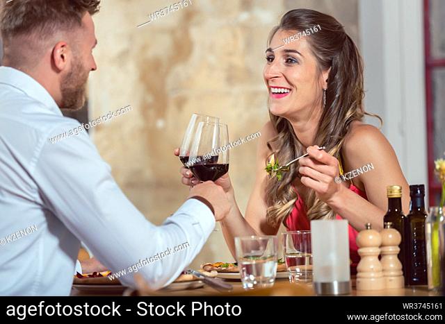 Young couple of a date enjoying red wine at restaurant