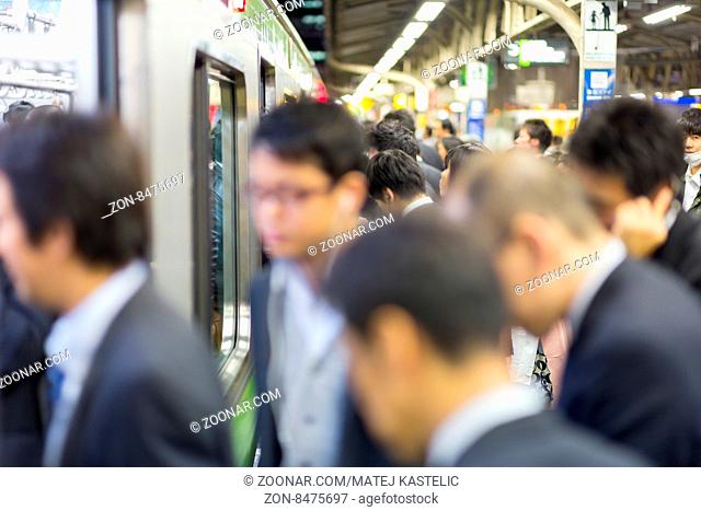 Corporate business people commuting to work by Tokyo public transport. Horizontal composition