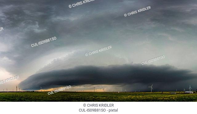 Supercell storm with shelf cloud over wind turbines, Oklahoma, USA
