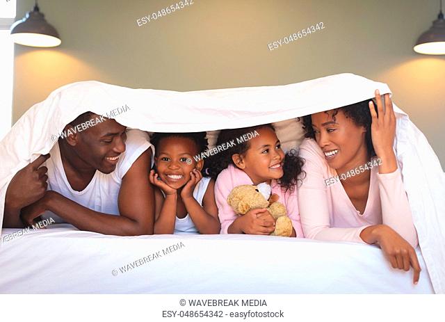 Happy African American family under blanket and looking each other