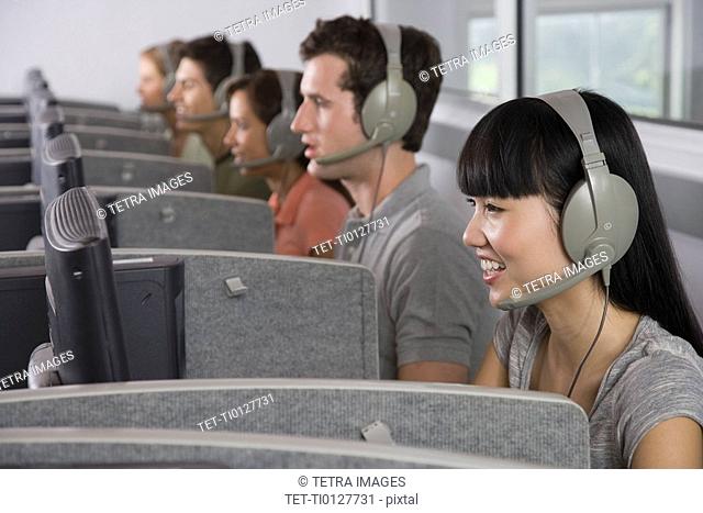 College students wearing headsets in computer lab