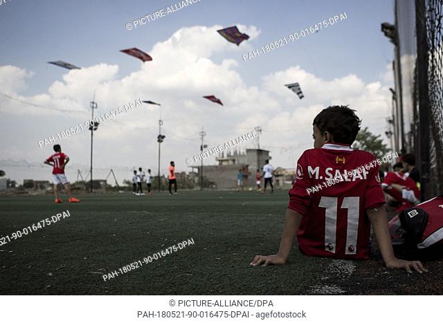 dpatop - A picture made available on 21 May shows an Egyptian boy wearing a t-shirt bearing the name of Liverpool's Mohamed Salah waiting for his turn to take...