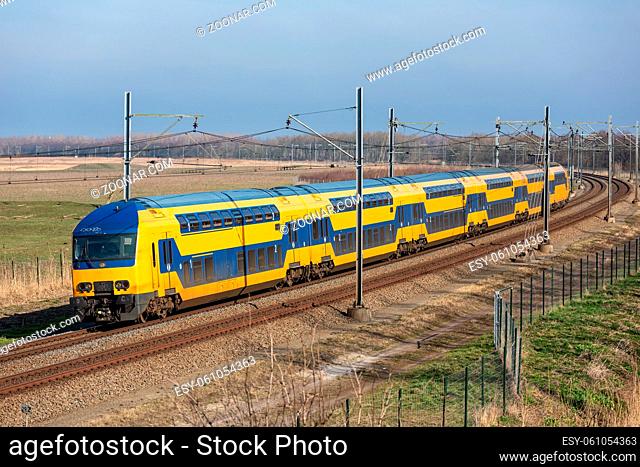 Dutch railway with double-decker express train through National Park Oostvaardersplassen between Lelystad and Almere