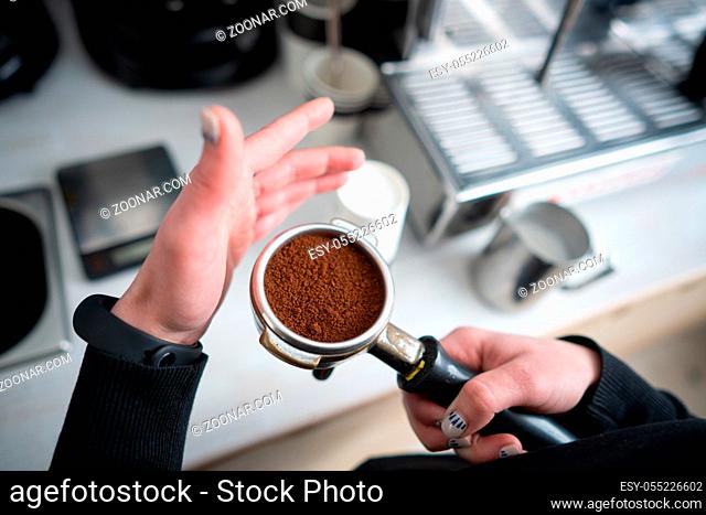 Barista holding portafilter with ground coffee in cafe for prepare to make espresso coffee
