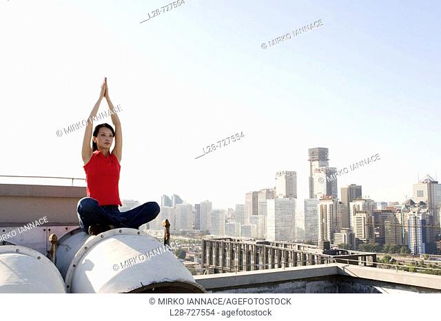 Woman doing yoga on roof
