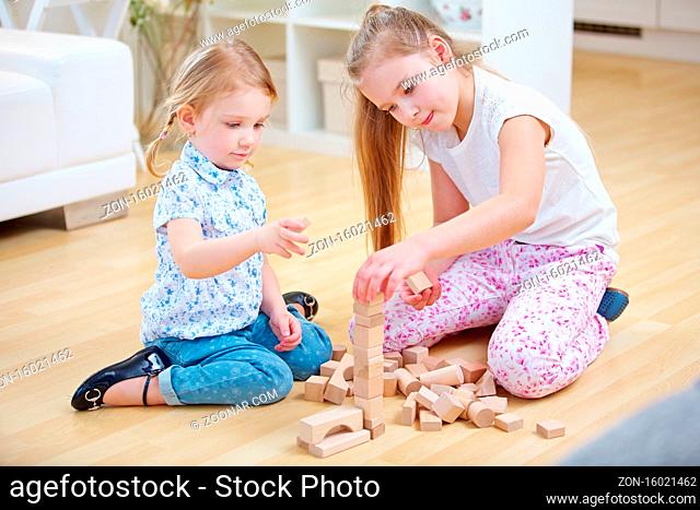 Zusammenarbeit von zwei Kindern beim Spielen mit Bausteinen zu Hause