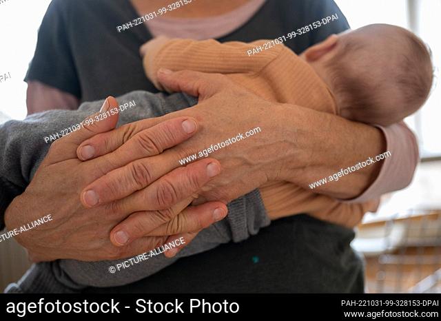 SYMBOL - 23 October 2022, Baden-Württemberg, Heidelberg: A grandmother holds her granddaughter in her arms. Photo: Sebastian Gollnow/dpa