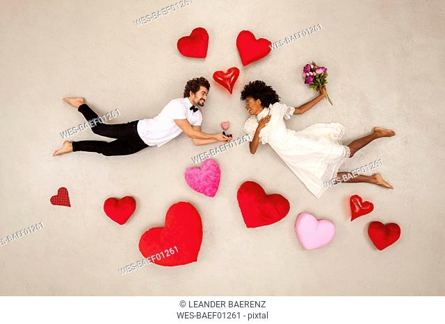 Young couple falling in love with hearts around