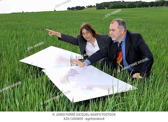 businesswoman and businessman with blueprints in the field
