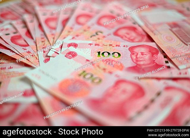 ILLUSTRATION - 12 December 2023, China, Peking: ILLUSTRATION - Several bills, each with a value of 100 Chinese renminbi (yuan), lie on a table