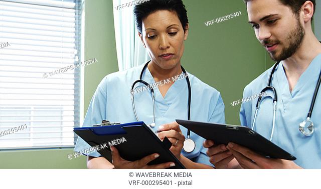 Two doctors discussing over digital tablet