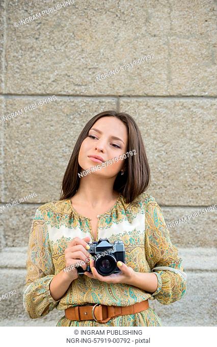Hipster woman taking photos with retro film camera