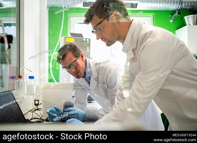 Scientists using laptop and working at laboratory