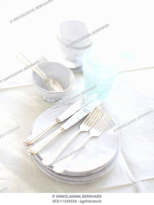 White crockery and glasses on a white tablecloth