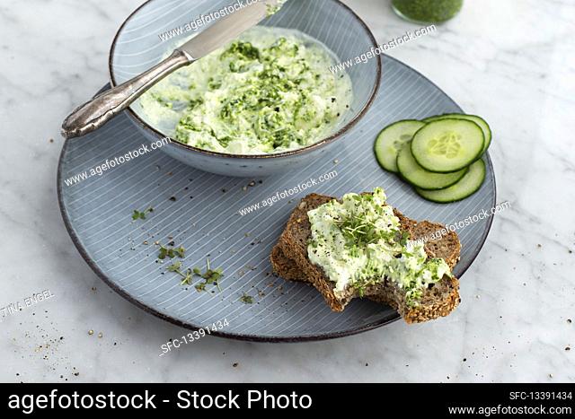 Wild garlic sheep's cheese cream on wholemeal bread with cucumber slices