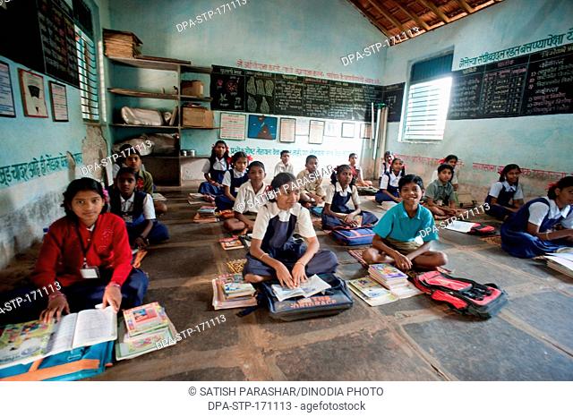 Girls and boys learning in classroom at Rajwadi ; Sangmeshwar ; Ratnagiri ; Maharashtra  ; India NOMR