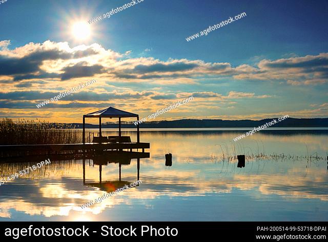 09 April 2016, Brandenburg, Gramzow: A pavilion at the Oberuckersee, in the background the low sun. The Uckermark is a popular tourist destination