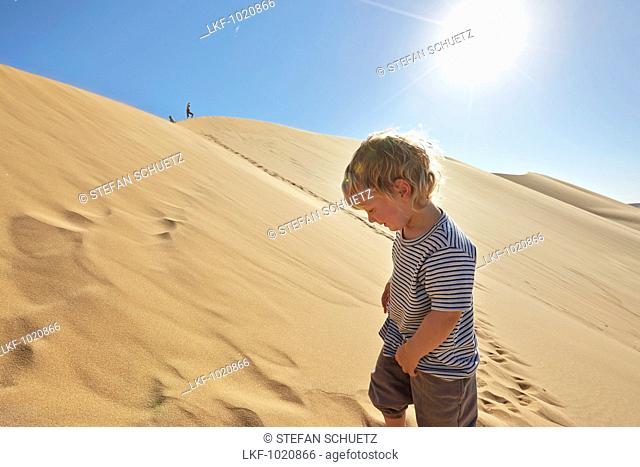 Boy in a sand dune, Dune 7, Walvis Bay, Erongo, Namibia