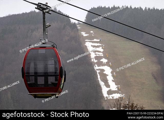 PRODUCTION - 14 January 2023, Hessen, Willingen: Remnants of snow lie behind a cabin of the Ettelsberg cable car on the ""Sonnenlift"" downhill slope in the...