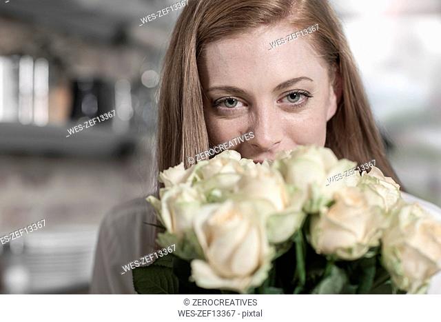 Portrait of young woman with bunch of roses
