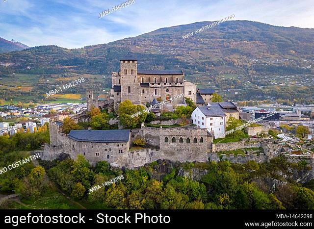 Aerial view of the Basilique de Valère dominating the city of Sion and the surrounding vineyards in autumn. Canton of Valais, valley of the Rhône, Switzerland