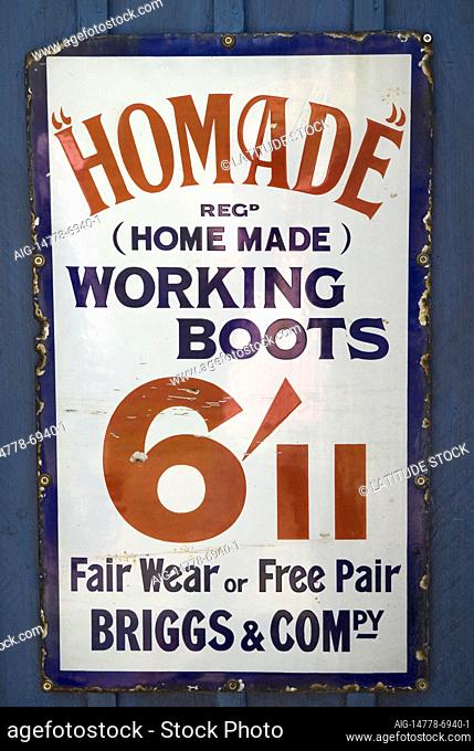 There are buildings and signs all along the Grand Union Canal, and advertising signs offering working boots at a reasonable price