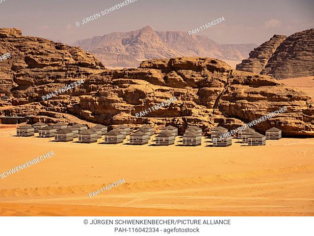In front of an impressive rock formation of the Wadi Rum desert stands a holiday camp of tents. The desert is one of the most important tourist destinations in...