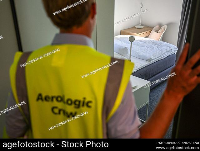 04 September 2023, Saxony, Schkeuditz: An employee wearing a high-visibility vest from AeroLogic stands in a lounge for pilots at the new LEJ Campus